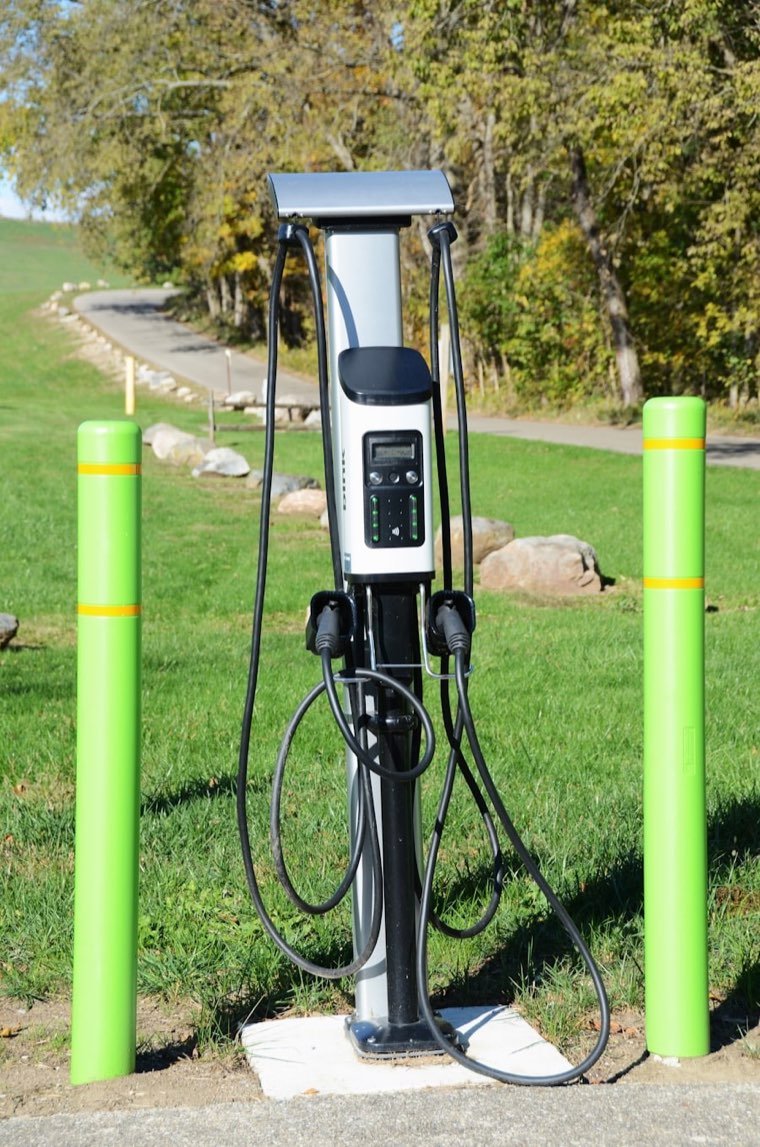 Borne de recharge sur un parking, avec deux câbles disponibles