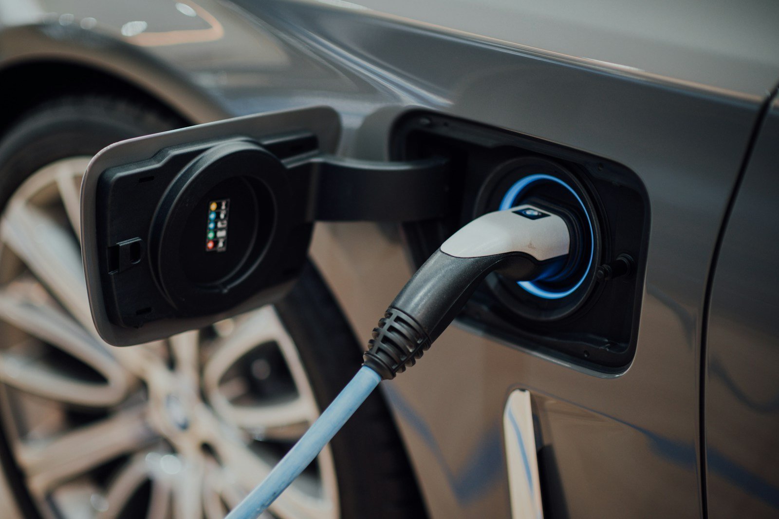 Câble de recharge branché sur la trappe d'un véhicule électrique, anneau lumineux bleu