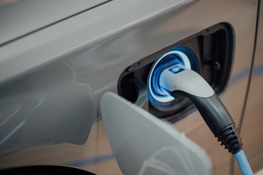 Connecteur de recharge branché sur un véhicule électrique, anneau lumineux bleu